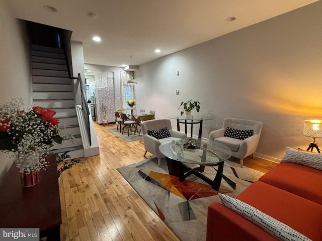 living area with baseboards, stairs, recessed lighting, and light wood-style floors
