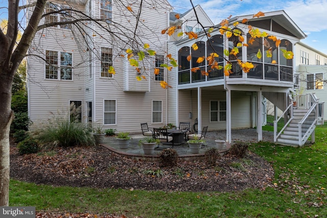 rear view of house featuring stairs, a patio, and a sunroom