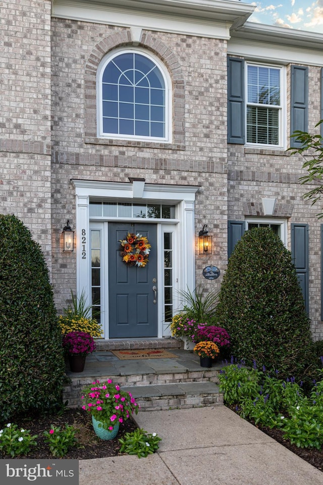 view of exterior entry with brick siding