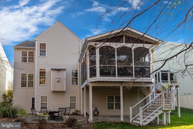 rear view of house with a sunroom, a patio, and stairway