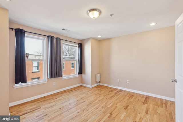 spare room featuring baseboards, visible vents, and hardwood / wood-style floors