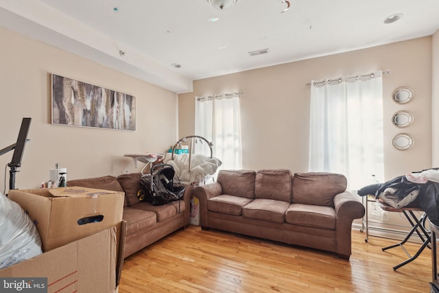 living area with visible vents and light wood-style floors