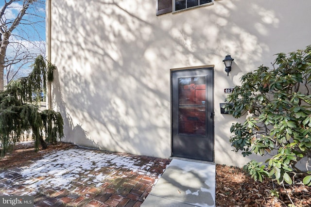 property entrance with a patio and stucco siding