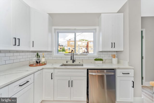 kitchen with a sink, stainless steel dishwasher, and white cabinetry