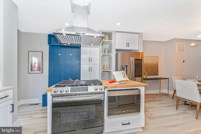 kitchen featuring visible vents, island exhaust hood, stainless steel appliances, white cabinetry, and open shelves