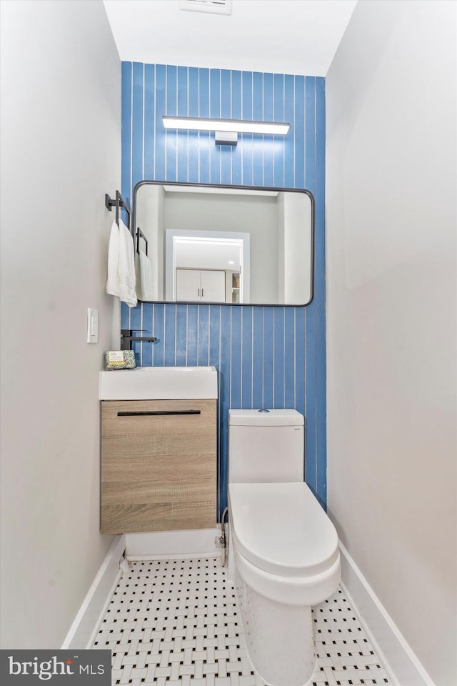 half bathroom featuring tile patterned flooring, toilet, and baseboards