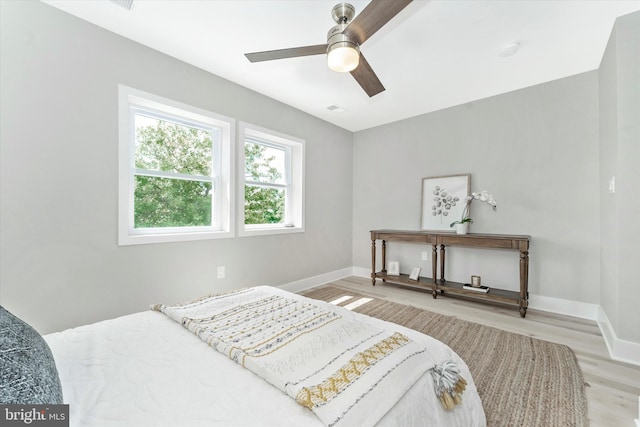 bedroom with visible vents, a ceiling fan, baseboards, and wood finished floors