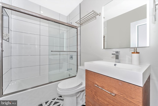 full bathroom featuring toilet, vanity, and bath / shower combo with glass door