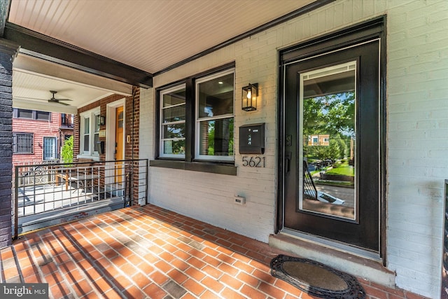 doorway to property featuring covered porch and brick siding