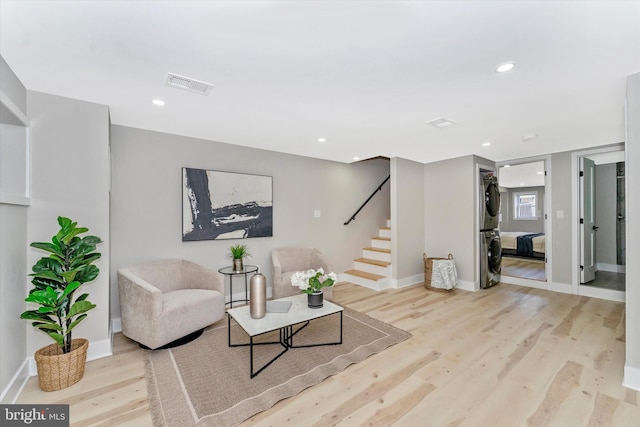 sitting room featuring stairway, visible vents, recessed lighting, stacked washer and dryer, and light wood-type flooring