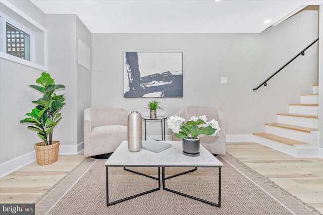 sitting room with stairway, baseboards, and wood finished floors