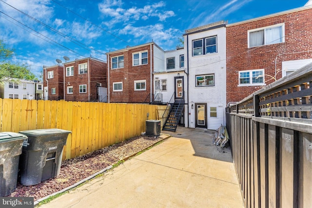 rear view of house featuring central air condition unit, fence private yard, and a patio