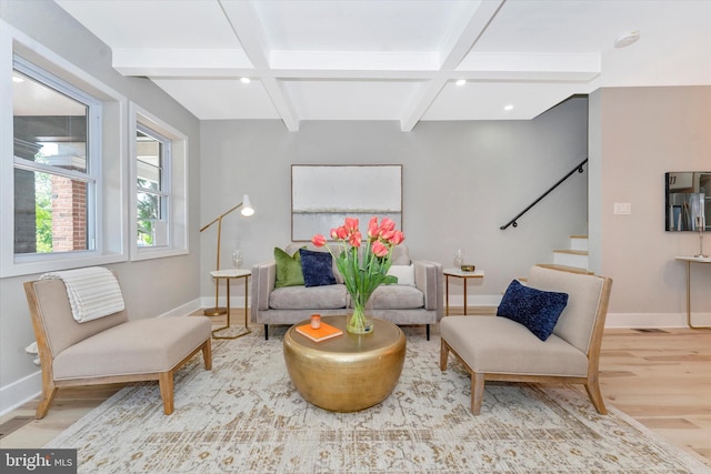 living room featuring beamed ceiling, stairs, baseboards, and wood finished floors