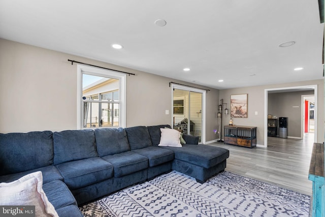 living room featuring baseboards, light wood-type flooring, and recessed lighting