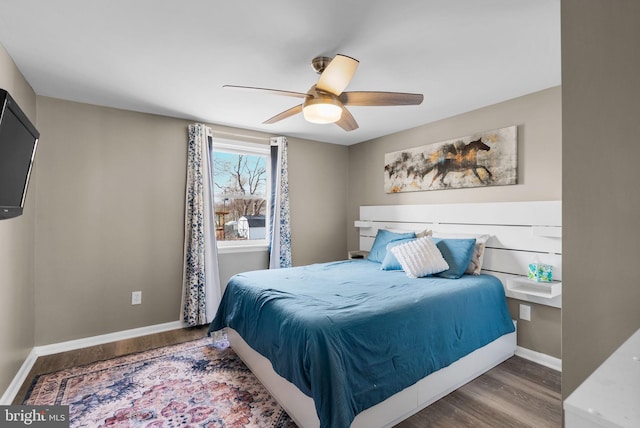 bedroom featuring a ceiling fan, baseboards, and wood finished floors