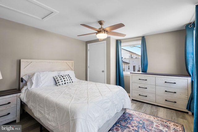 bedroom featuring ceiling fan, wood finished floors, and attic access