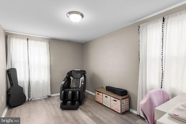 living area with baseboards and wood finished floors