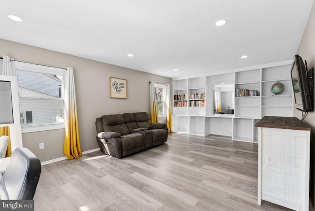 living room featuring light wood-style floors, recessed lighting, plenty of natural light, and baseboards