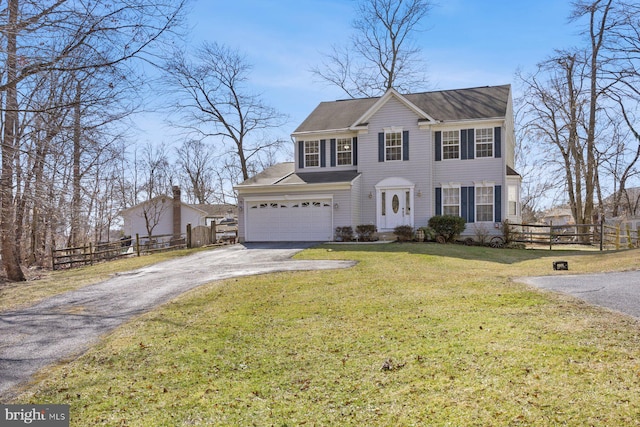 view of front of house featuring aphalt driveway, a garage, fence, and a front lawn