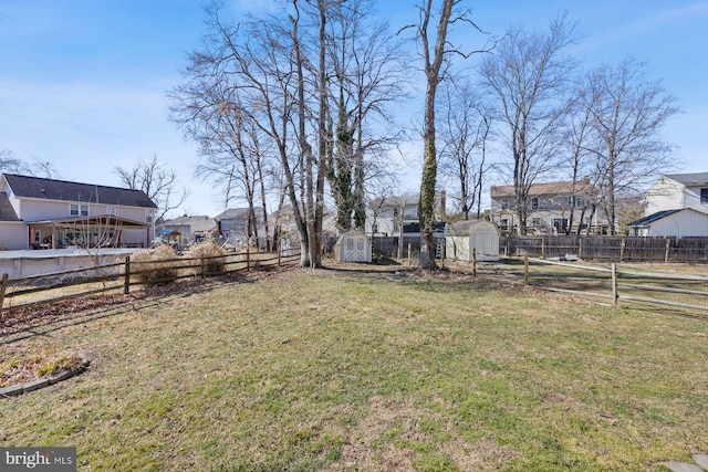 view of yard with a storage shed, an outdoor structure, and fence