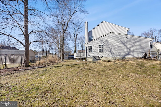 exterior space with a chimney, fence, and a yard