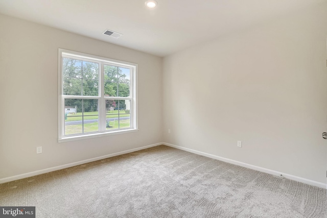 spare room with baseboards, visible vents, and carpet flooring