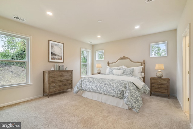 bedroom with multiple windows, recessed lighting, visible vents, and light colored carpet