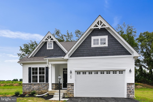 craftsman-style house with metal roof, driveway, a standing seam roof, and stone siding