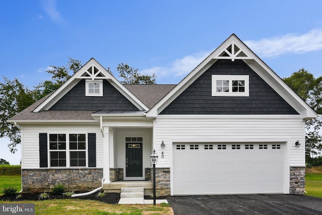 craftsman-style house with stone siding, aphalt driveway, and roof with shingles