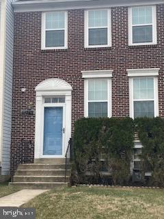 view of front of house featuring entry steps, a front yard, and brick siding