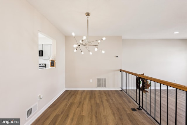 interior space with an inviting chandelier, visible vents, baseboards, and wood finished floors