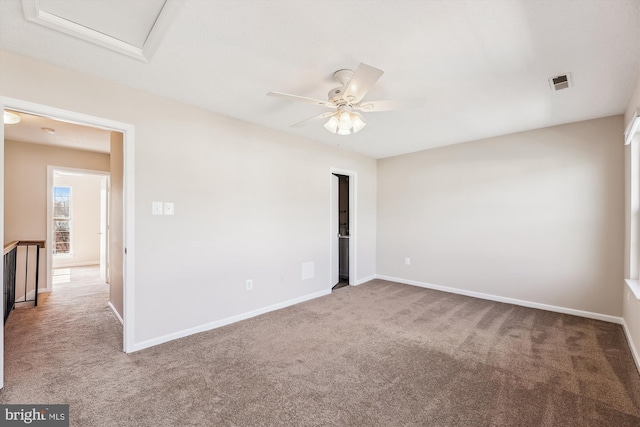 unfurnished room featuring carpet, visible vents, and baseboards