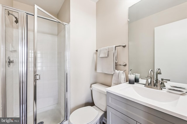 bathroom featuring a shower stall, toilet, and vanity