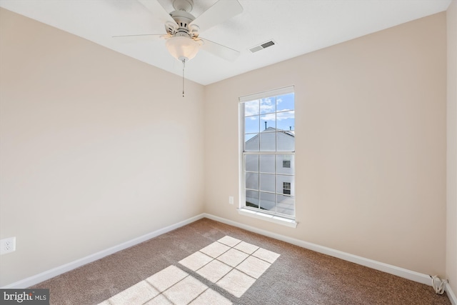 spare room featuring carpet floors, visible vents, ceiling fan, and baseboards