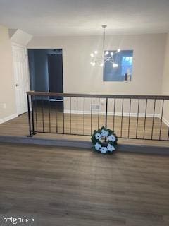 interior space with baseboards, an inviting chandelier, and wood finished floors