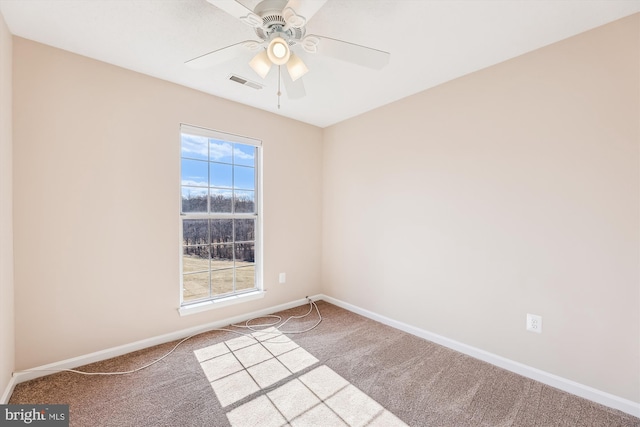 empty room featuring a ceiling fan, carpet flooring, visible vents, and baseboards