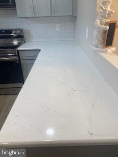 interior space with black microwave, electric stove, and gray cabinets