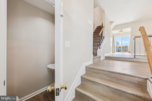 stairway with baseboards and wood finished floors