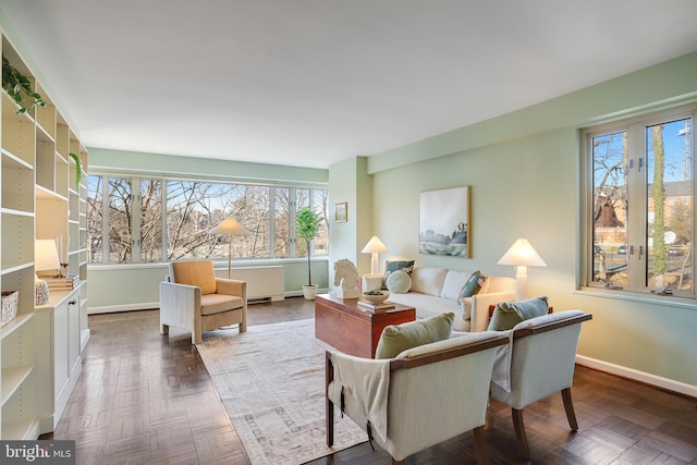 living room featuring baseboards and a healthy amount of sunlight