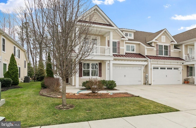 multi unit property featuring a front yard, central AC unit, driveway, an attached garage, and a standing seam roof