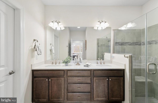 bathroom featuring double vanity, a shower stall, and a sink