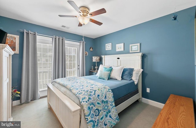 carpeted bedroom featuring access to exterior, visible vents, a ceiling fan, and baseboards