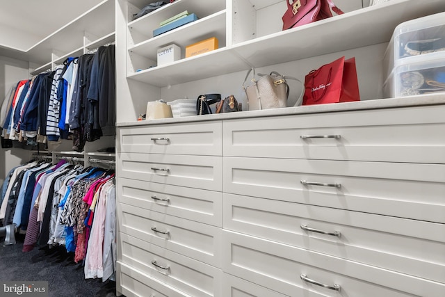 walk in closet featuring dark carpet