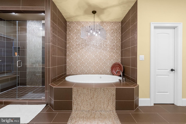 bathroom with a stall shower, tile patterned flooring, baseboards, and a bath