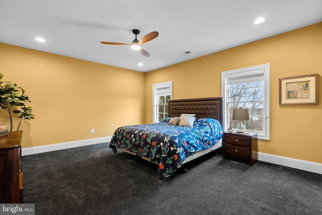 bedroom with dark colored carpet, multiple windows, visible vents, and baseboards