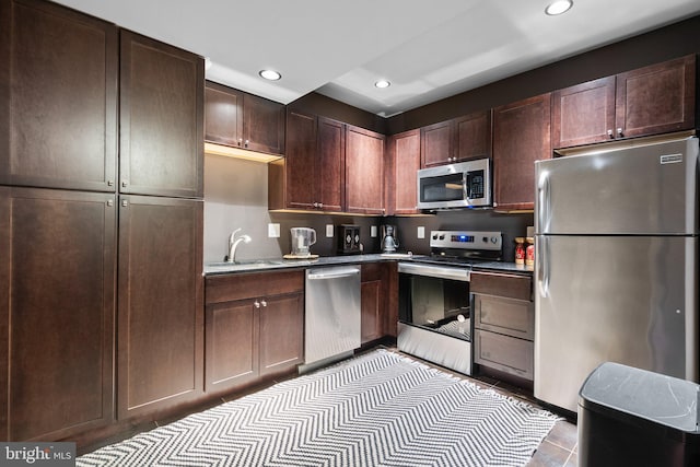 kitchen featuring appliances with stainless steel finishes, recessed lighting, a sink, and dark brown cabinets