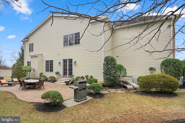 rear view of house featuring entry steps, a patio area, and a yard