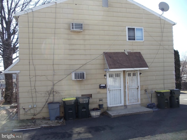 rear view of property featuring roof with shingles