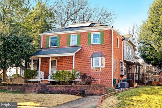 view of front of property featuring brick siding and solar panels