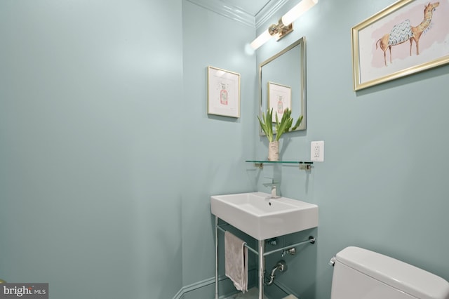 bathroom with ornamental molding, vanity, and toilet